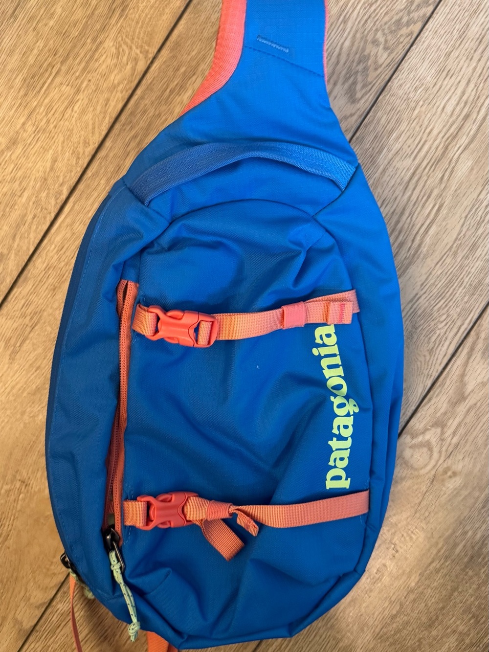 Patagonia blue sling bag with orange straps